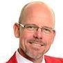 A person in glasses and red jacket smiling.