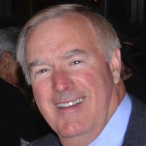 A person smiling in a formal setting.