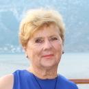 A person wearing a blue outfit with a scenic background.