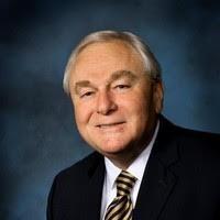 A person in a suit and tie smiling.