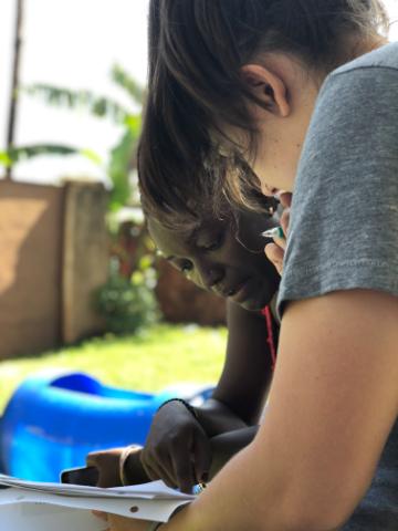Two people reviewing green documents outdoors for farming plans.