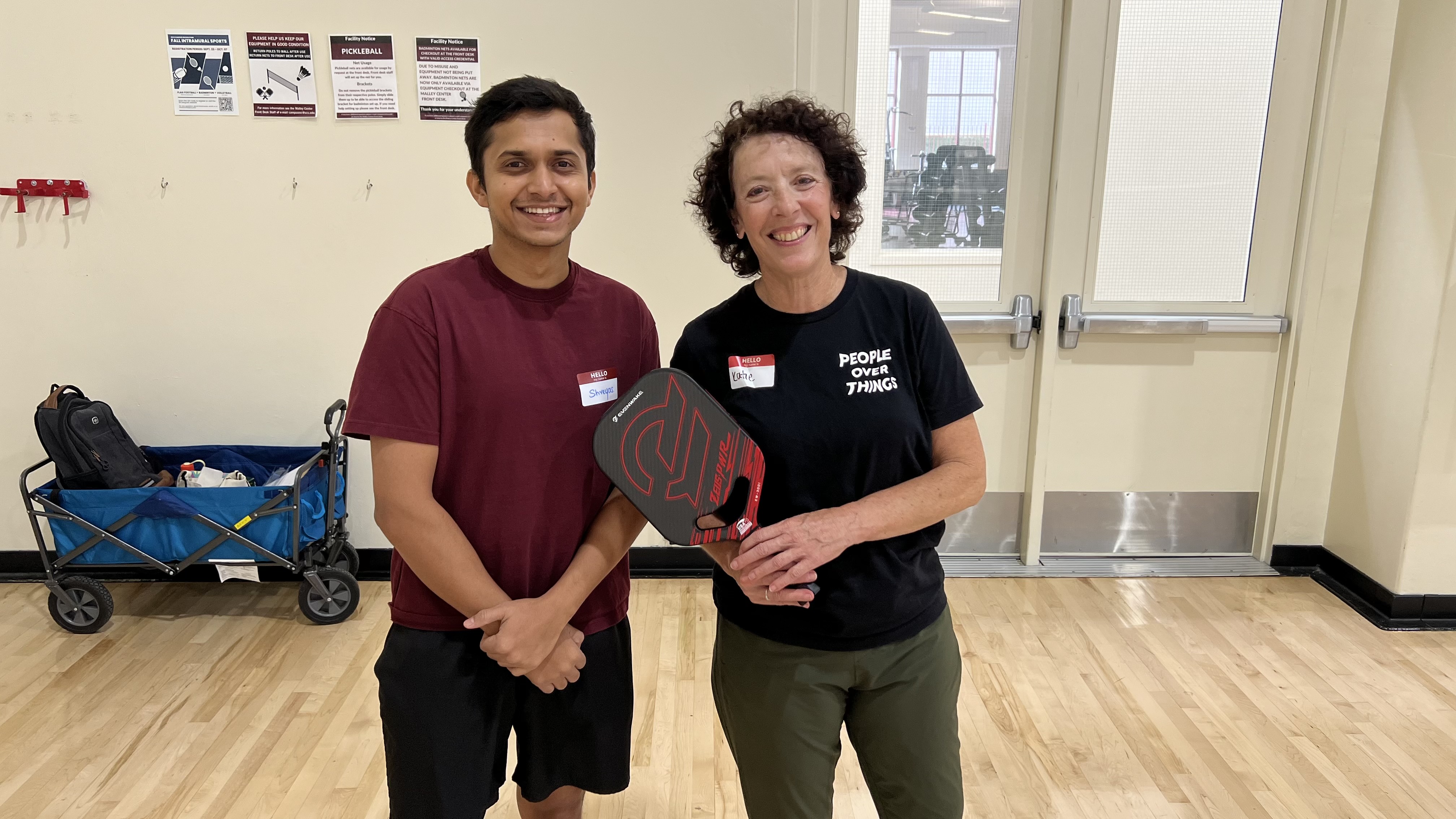 Decorative; student and staff member holding pickleball rackets