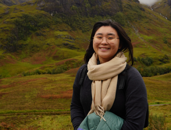 Decorative; student smiling in front of a mountain landscape 