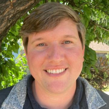 A person smiling outdoors, titled 'Ethan'.