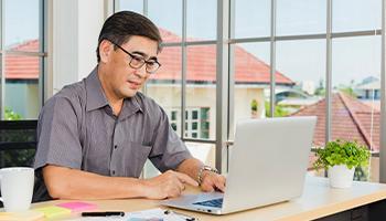 A man sits with his laptop 