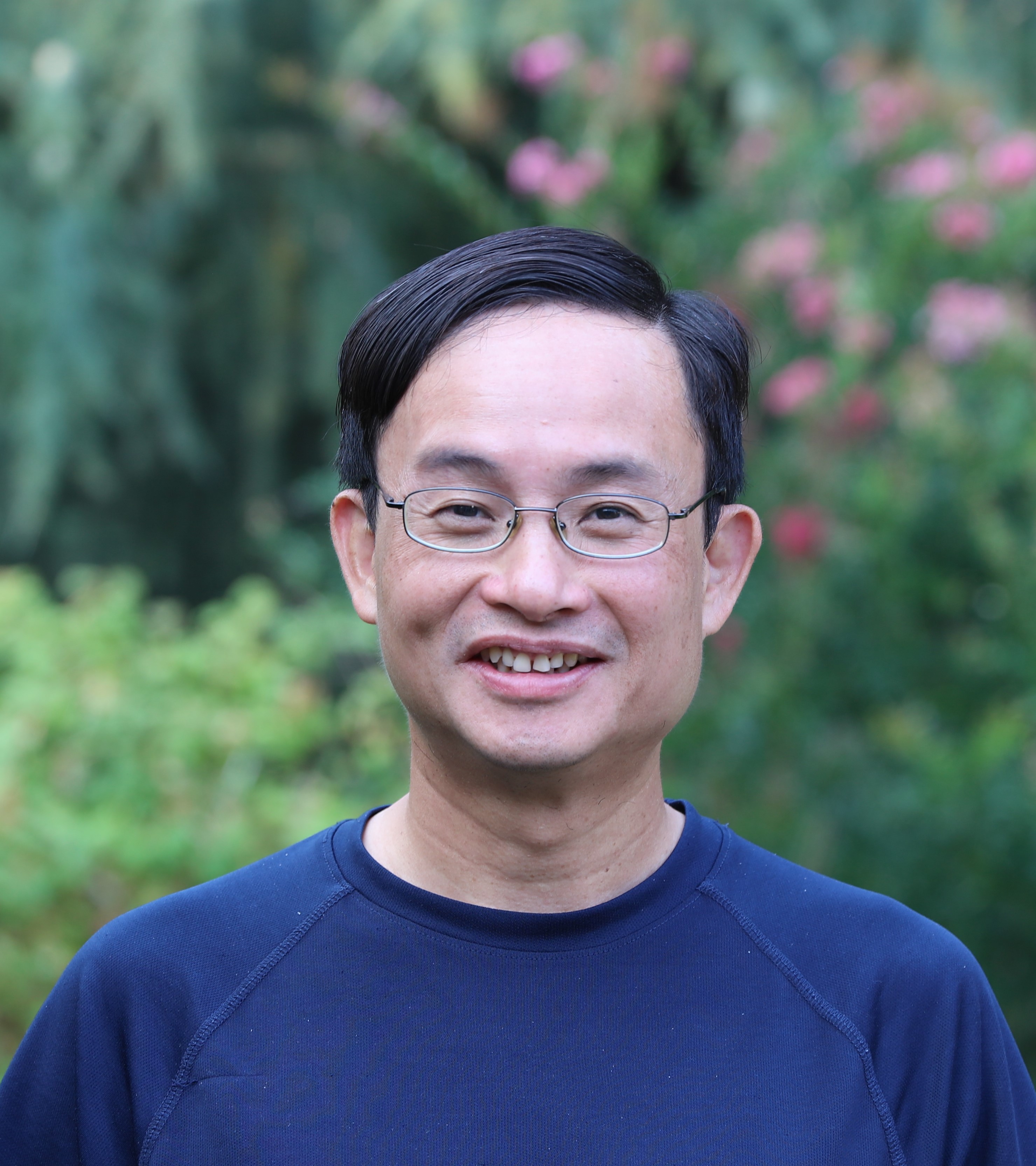 A person smiling outdoors in a lush, green setting. image link to story