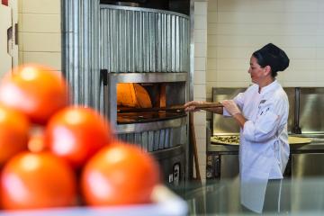 A chef tending to a pizza in 540's oven. 