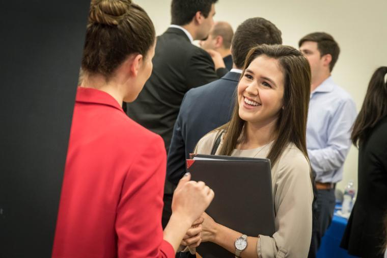 Girl student talking to representative at career fair 