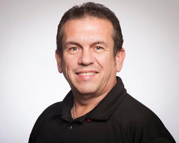 A smiling person named Joe Pereira wearing a black shirt.