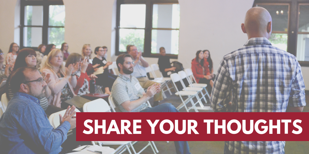 A speaker addresses a seated audience, with 