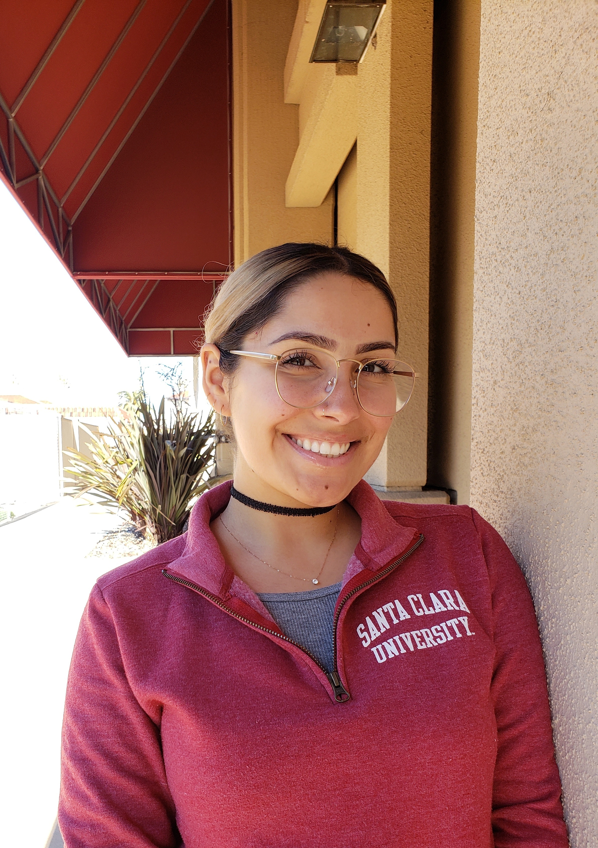 A person smiling, wearing a maroon sweater with 