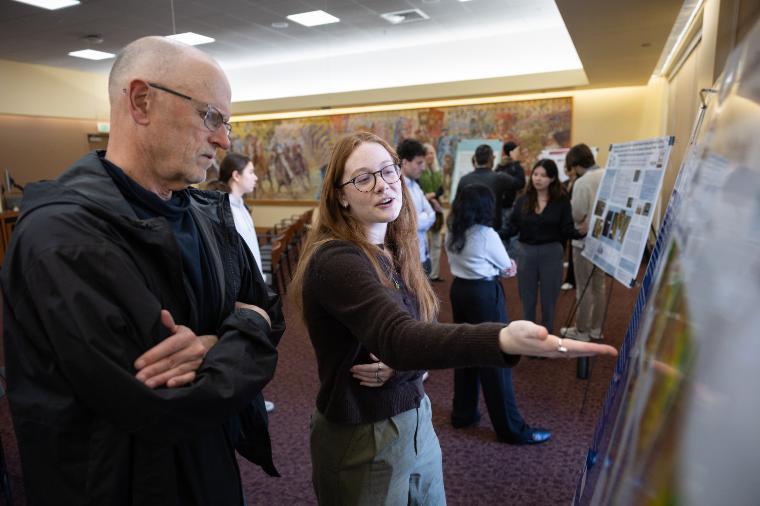 A student researcher speaking at a poster session