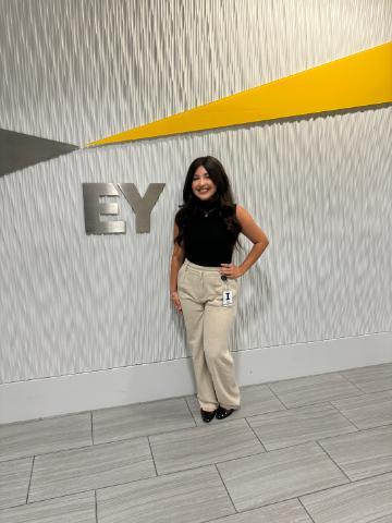 SCU student Raechel Guevara stands in front of a sign at EY