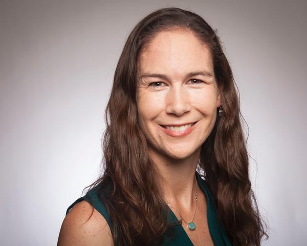 Woman in a sleeveless top smiling in a professional headshot.