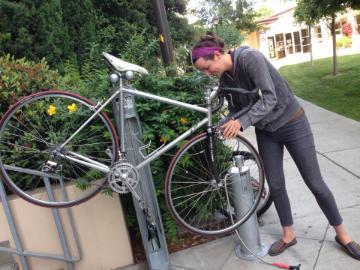 Person using tools at a bicycle fix-it station.