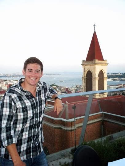 A person giving a thumbs-up with a tower in the background.