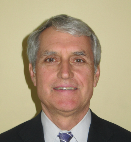 A man smiling in a suit and tie. image link to story