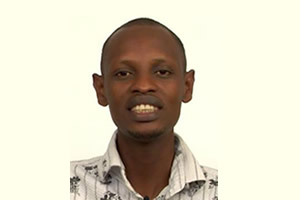 Alt text: Person smiling in front of a plain background. image link to story