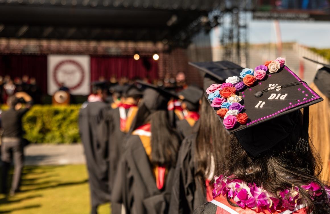 A group of graduates listening to commencement remarks.
