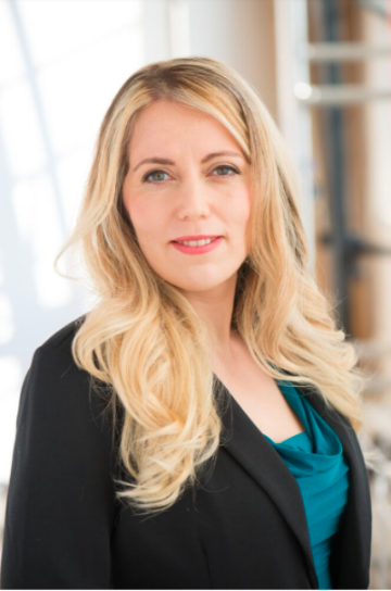 Alt text: "Dr. Maya Ackerman posing in a professional setting."