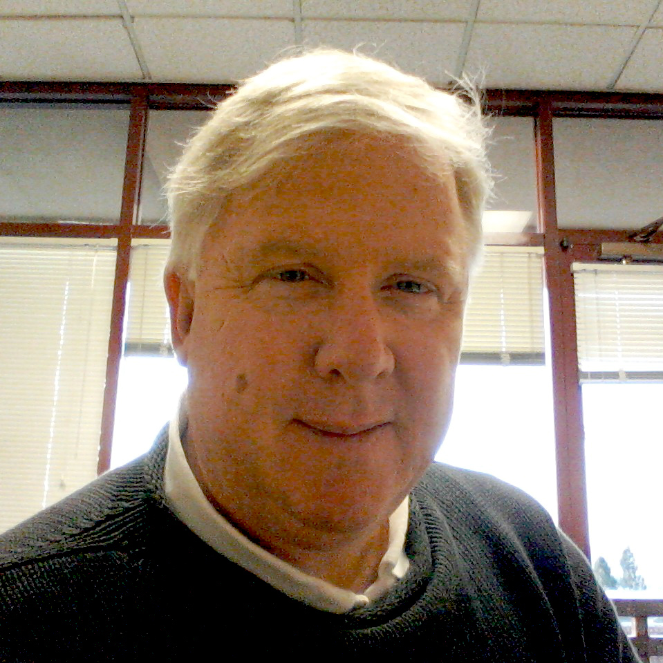 Man in black sweater with a white collar in an office. image link to story