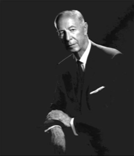 Portrait of George L. Sullivan in a suit with crossed arms.