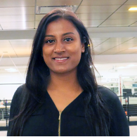 A woman in a black top standing indoors.