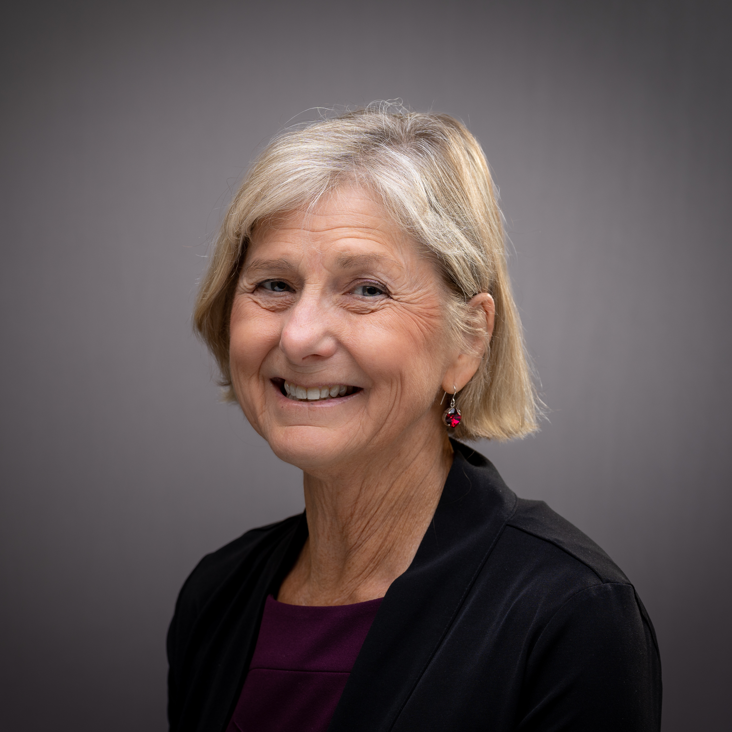 A person smiling with a neutral background. image link to story