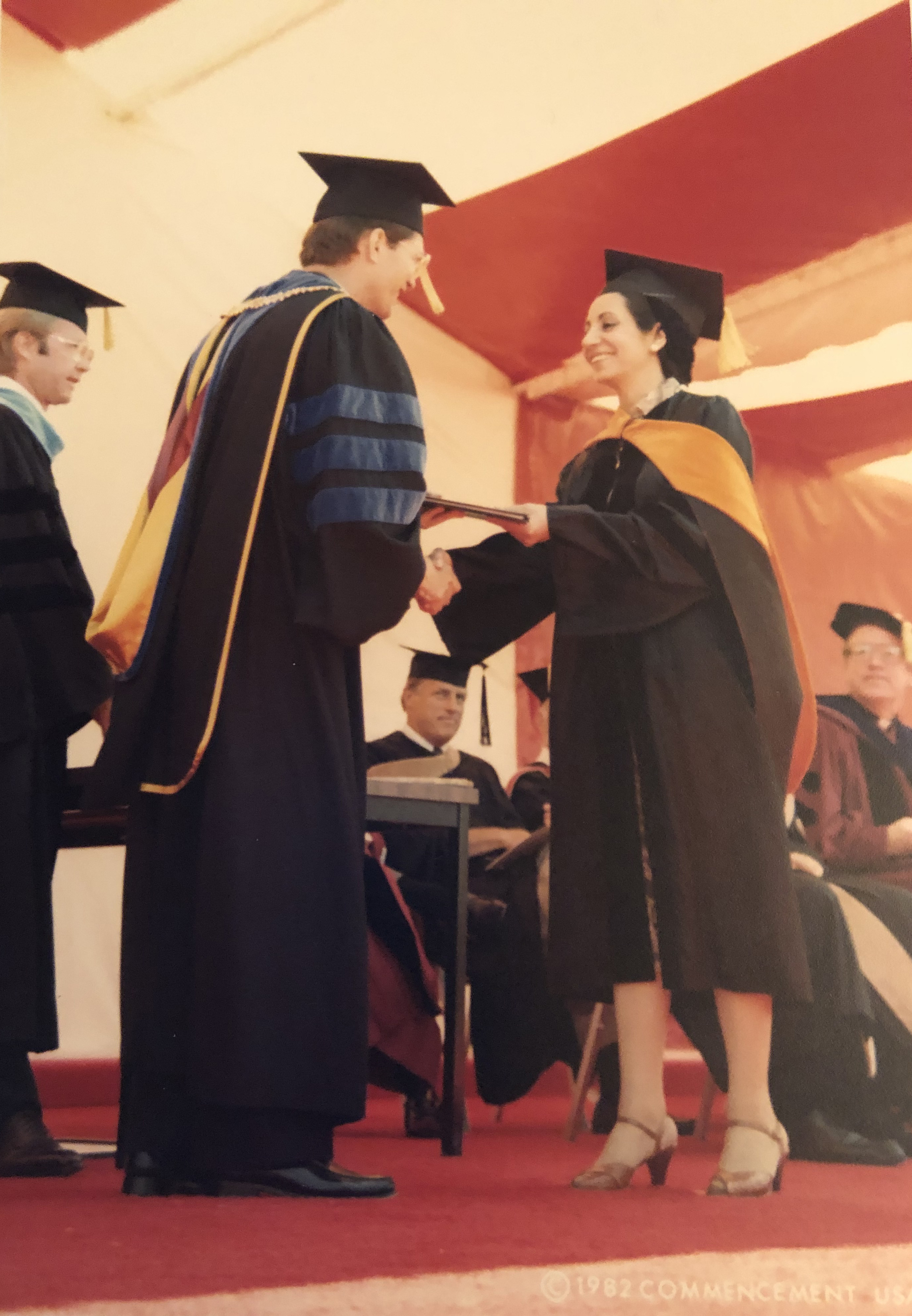 Several people in academic regalia at a graduation ceremony.