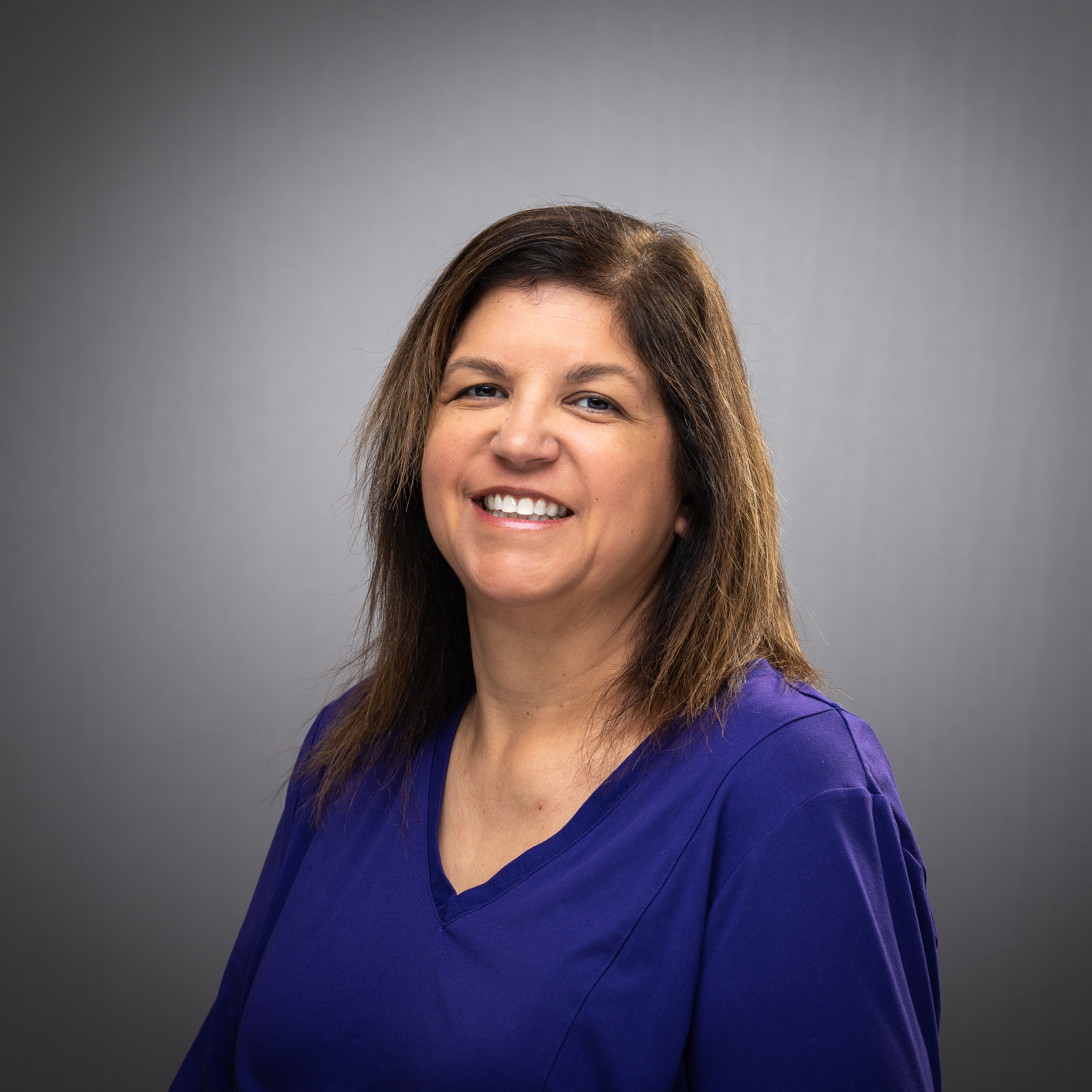 A person smiling against a plain background.