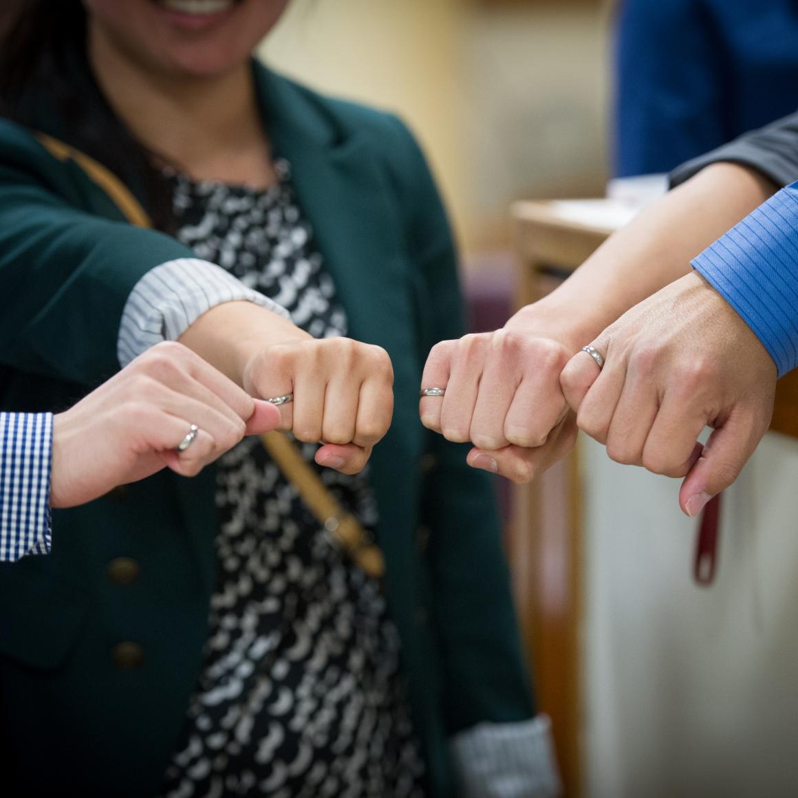 Four students show off their new Order of the Engineer rings