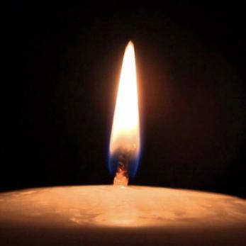 A candle burning against a black background
