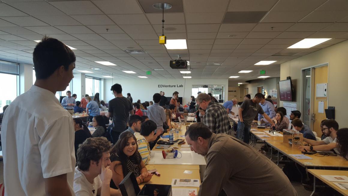 Students and instructors at a robotics show in a classroom setting.