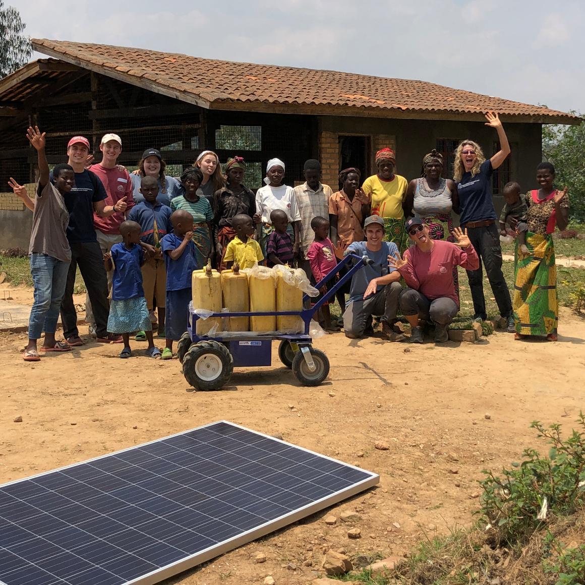 SCU Engineers Without Borders student and faculty in Rwanda with electric cart and solar panel