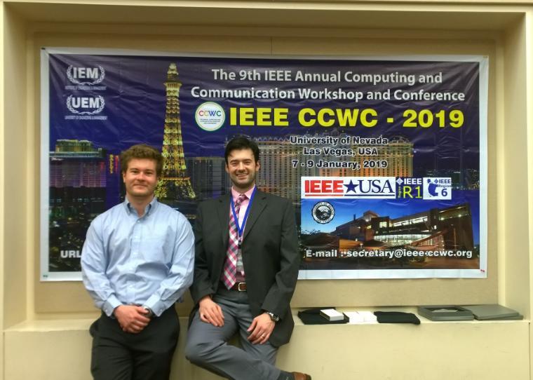 Two men smile in front of