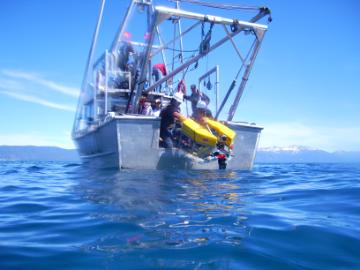 Student launches a UAV from the back of a boat at Lake Tahoe