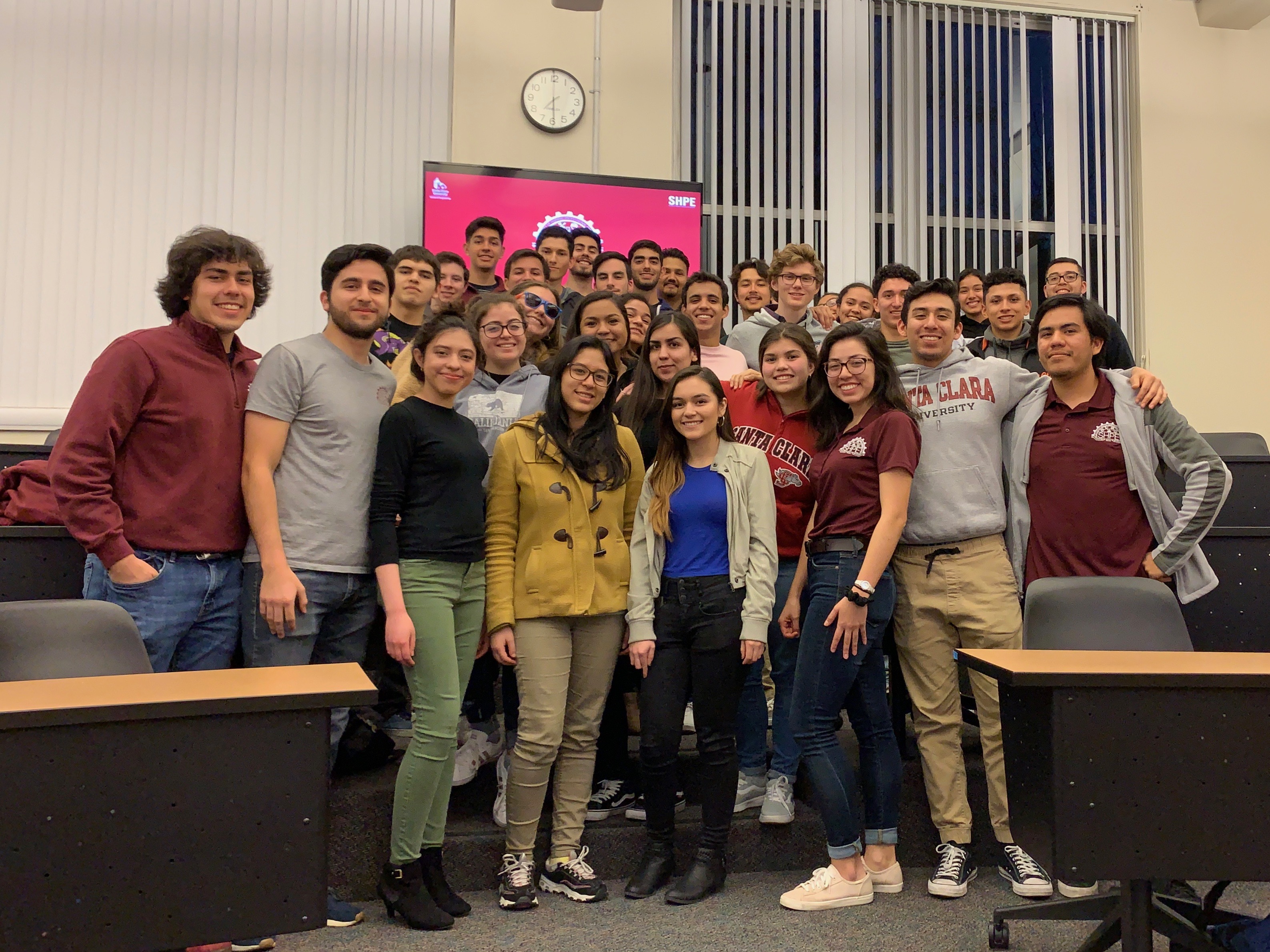 A group of people standing together in a classroom.