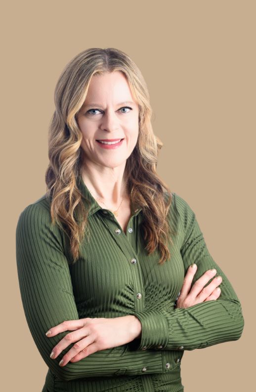 professor Christine Morgan a woman with long blonde hair and a green collared shirt with her arms crossed over her chest