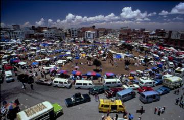 Busy transportation hub with numerous vehicles and pedestrians.